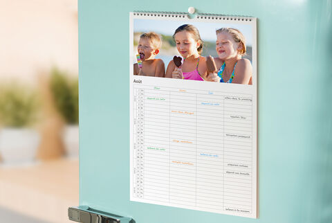 Un calendrier coloré avec des enfants joyeux sur un réfrigérateur.
