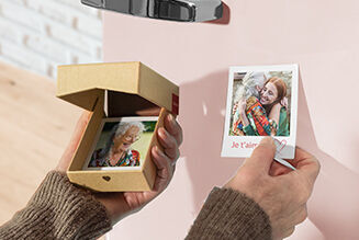 Deux personnes tiennent une petite boîte et une photo montrant un souvenir affectueux.