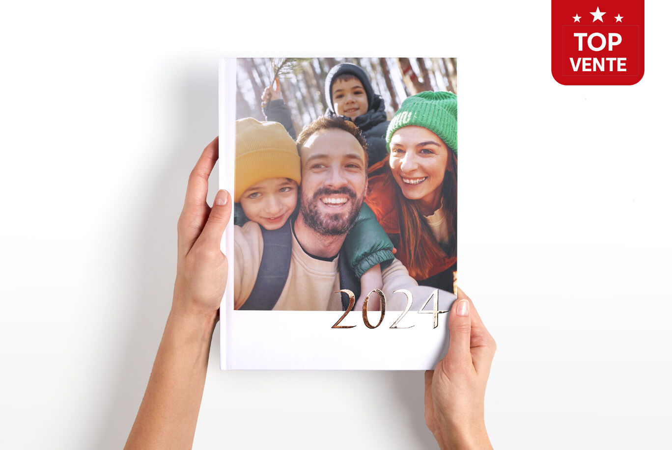 Livre Photo CEWE A4 portrait tenu entre les mains avec le logo Top Vente