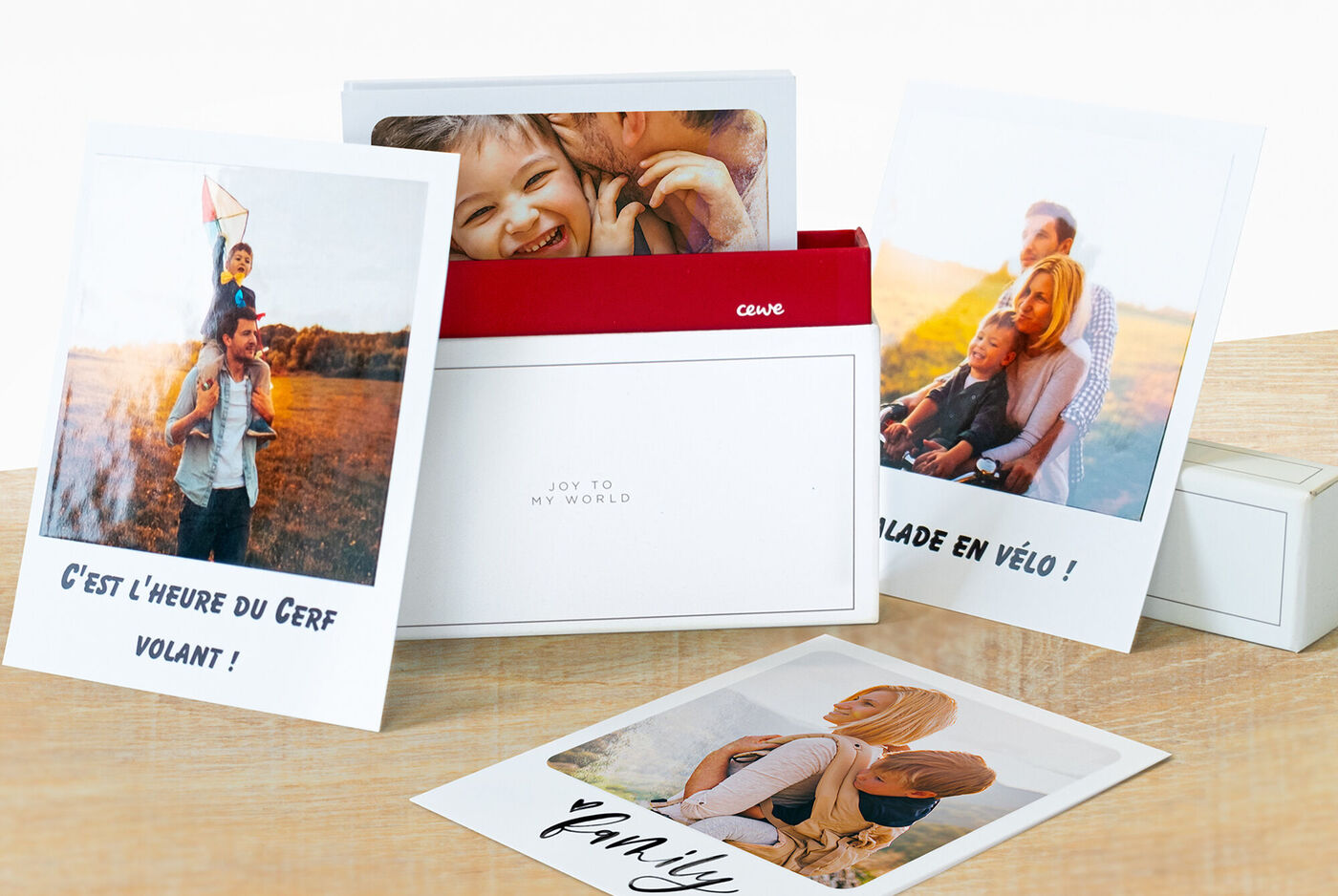 Sélection aimante de photos dans un paquet CEWE présenté sur table en bois