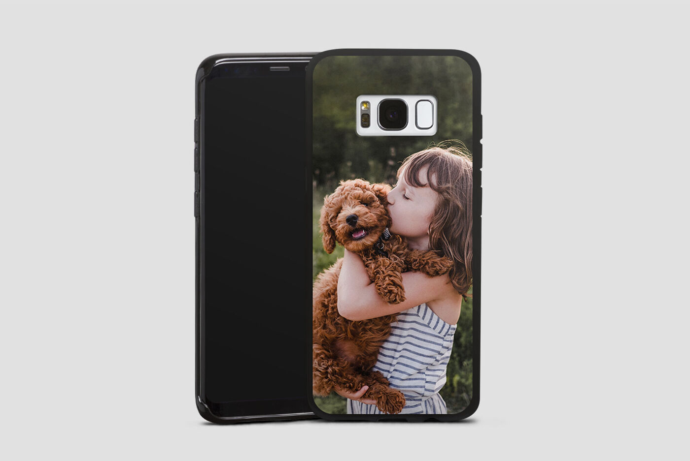 Un enfant joyeux tient un chien dans les bras et sourit joyeusement.