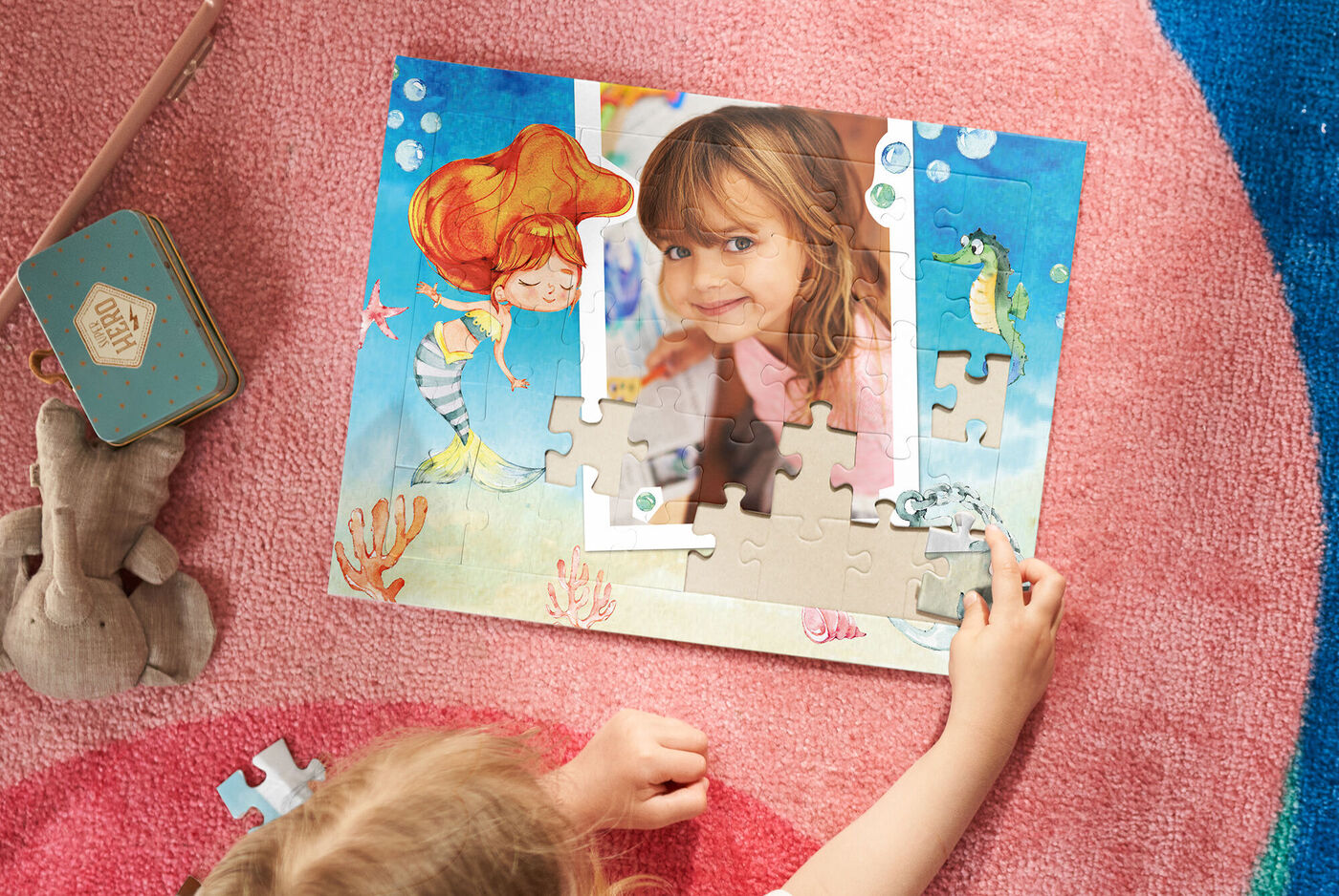 Un enfant assemble des pièces de puzzle sur un puzzle coloré avec une sirène.