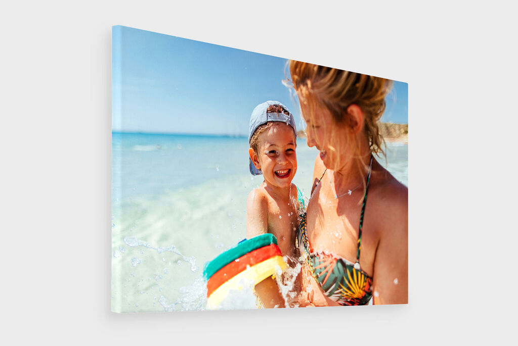 Une mère avec son enfant profite d'une journée ensoleillée à la plage, avec en arrière-plan l'eau claire de la mer.