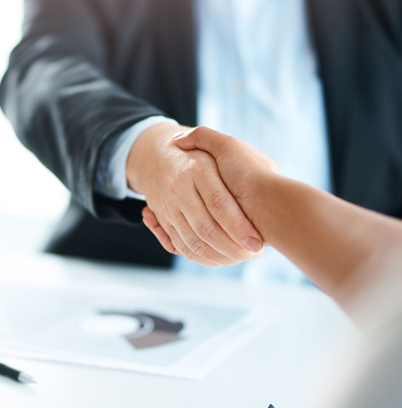 Deux personnes se serrent la main pour une salutation dans un contexte commercial