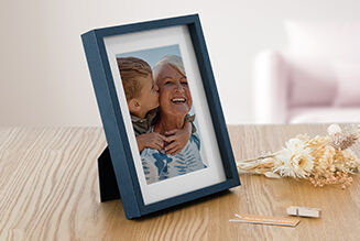 Une photo affectueuse dans un cadre sur une table, entourée d'éléments décoratifs.