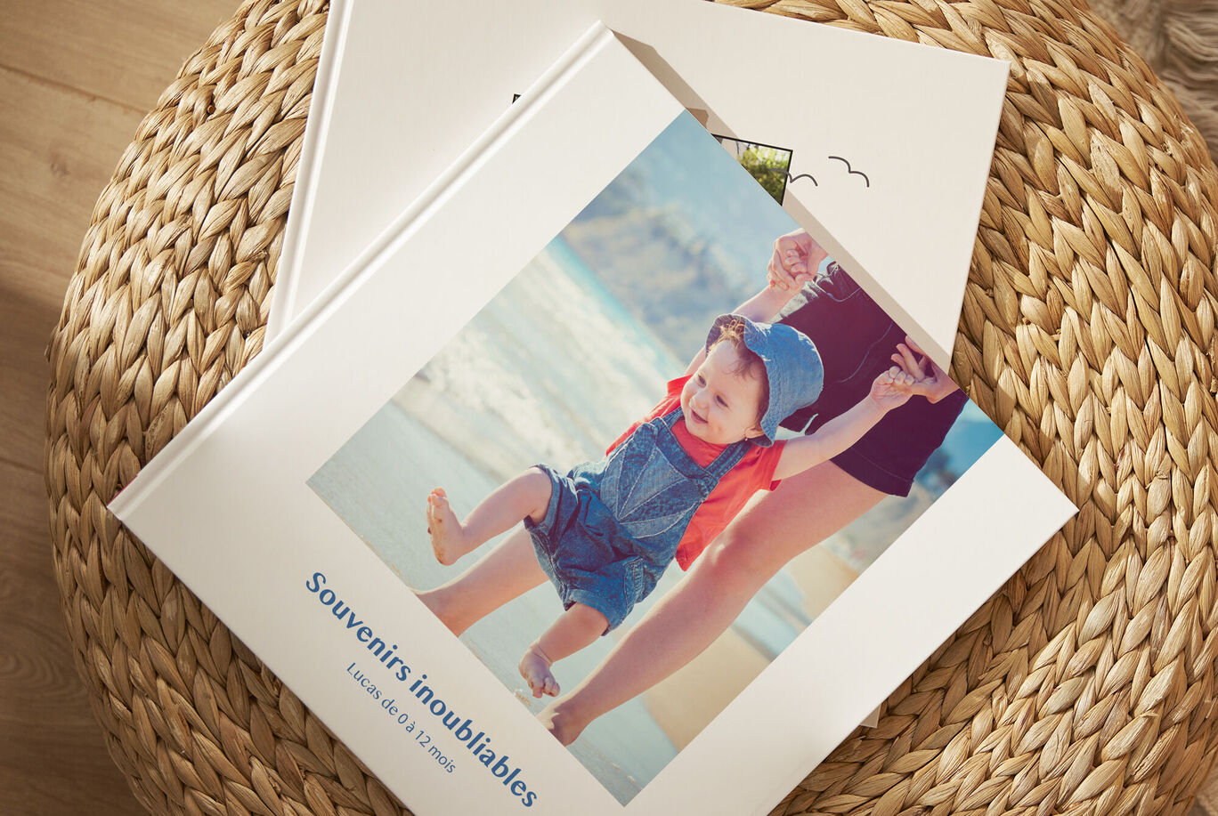 Un livre photo CEWE avec des souvenirs d'un enfant à la plage. Il montre des moments heureux de jeux dans le sable.