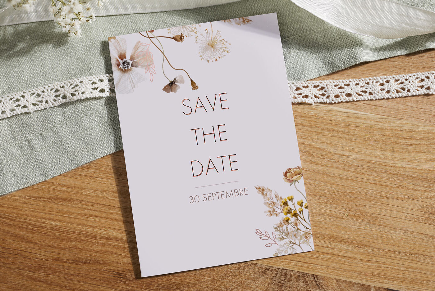Une carte Save-the-Date moderne pour un mariage avec des accents floraux et la date du 30 septembre.