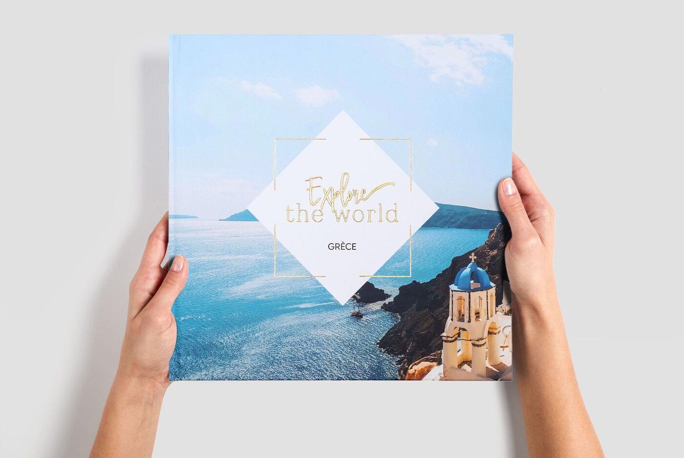 Grand album photo carré de vacances en Grèce, tenu entre 2 mains