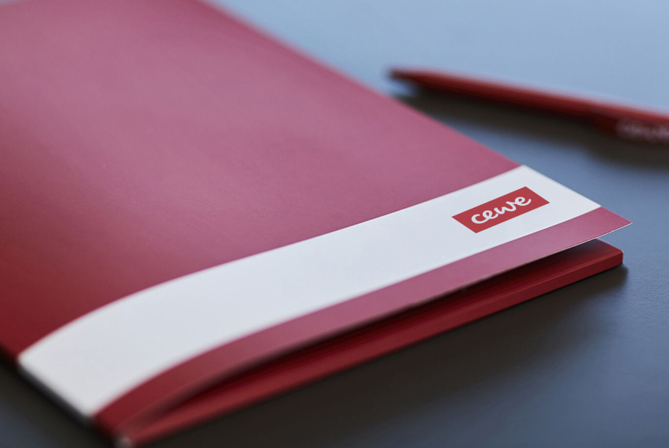 Cahier rouge de CEWE sur une table.