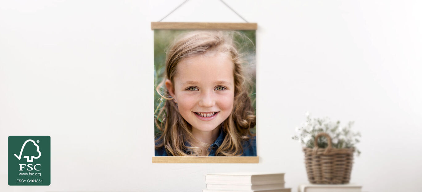 Une belle image d'une fille devant un décor verdoyant, accrochée à un mur avec un cadre en bois.