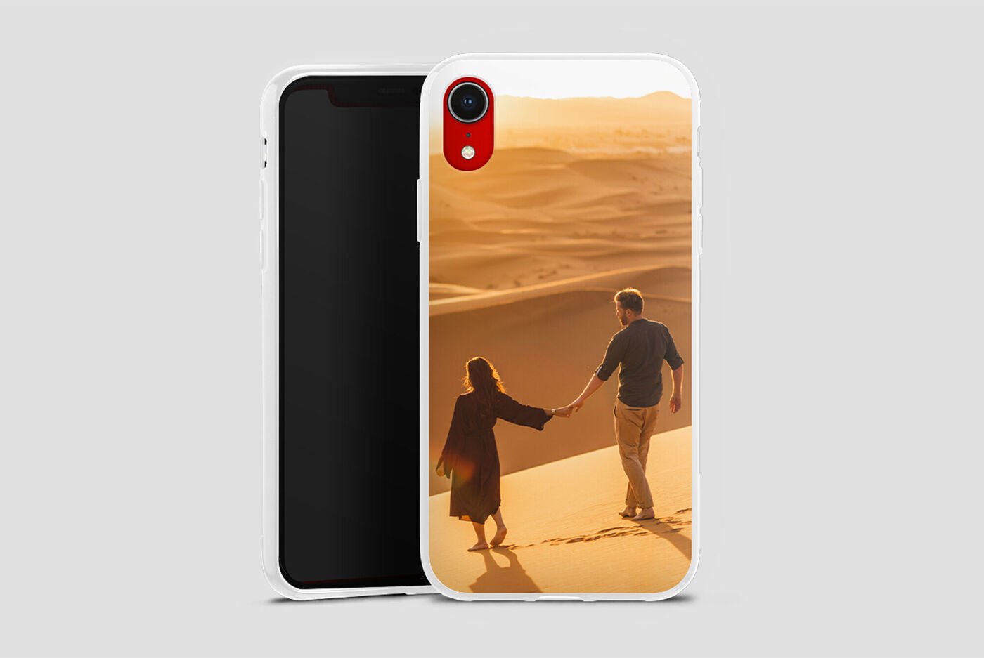 Un couple se tient par la main sur la plage, éclairé par la lumière du soleil