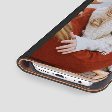 Une personne tient un smartphone en se blottissant sous une couverture