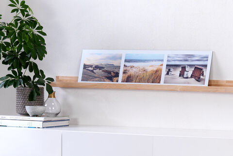 Trois photos de paysages de plage sur une étagère pour souligner les souvenirs de vacances.