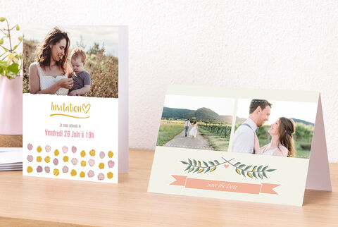 Deux belles invitations sur une table, l'une avec un cœur et l'autre avec un design floral.