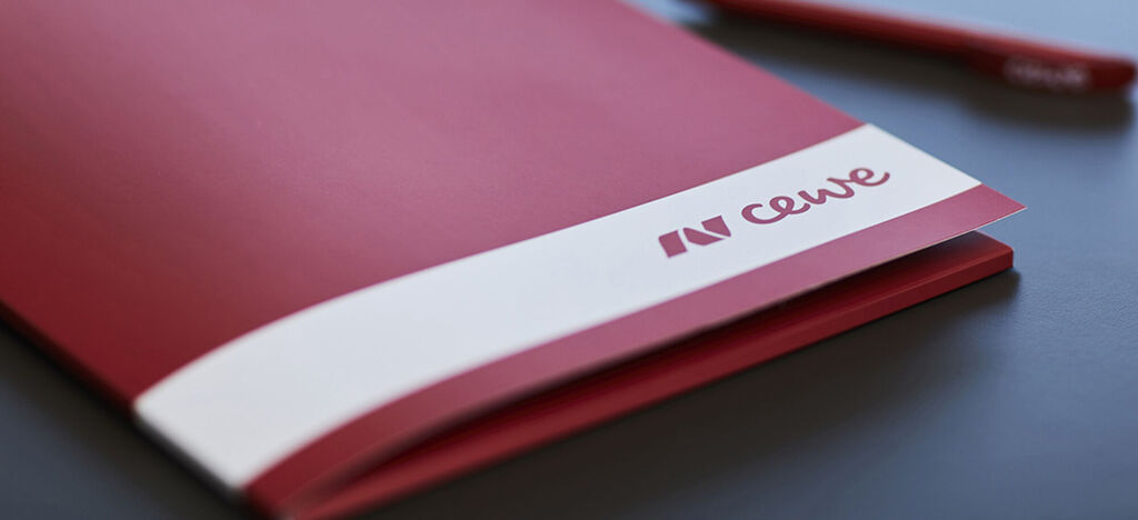 Cahier rouge et stylo à bille avec le logo CEWE