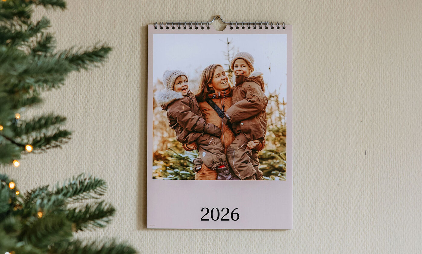 Un calendrier mural montre une scène familiale affectueuse avec des enfants à l'extérieur.