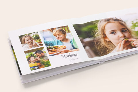Un album photo A4 paysage ouvert montrant des photos d'enfants et écrit dessus Barbecue en famille