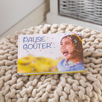 Un album photo A5 paysage 19x15 cm avec en couverture une photo d'enfant et écrit dessus Pause Goûter