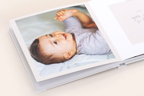 Album photo carré ouvert avec la photo d'un bébé souriant