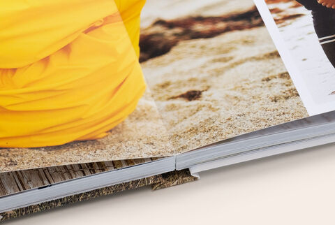 Zoom sur la reliure d'un album photo A4 portrait avec ouverture à plat montrant des photos d'enfants à la plage